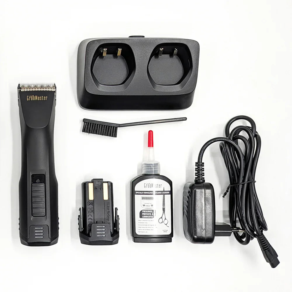 Groomaster grooming kit with clipper, charger, brush, oil bottle, and charging cable on a white background