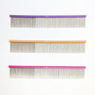 Three combs with different colored handles on a white background