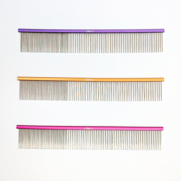 Three combs with different colored handles on a white background