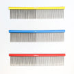 Three combs with different colored handles on a white background